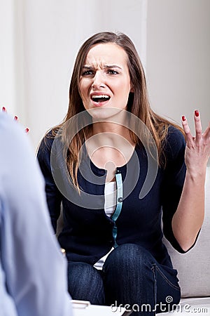 Angry young woman during psychotherapy Stock Photo