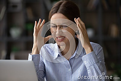 Angry young woman worker look at laptop screen making mistake Stock Photo