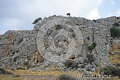 Wild mountain goats climb down steep rocky mountains. Rhodes Island, Greece Stock Photo