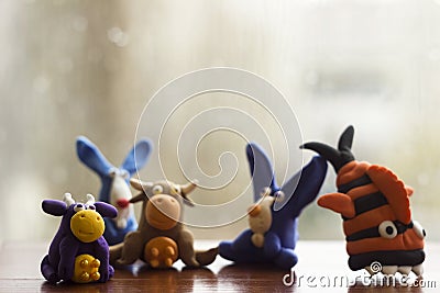 Animals rabbits, cows and fish from multi-colored plasticine, which hardens. Children`s creativity. Funny clay toys Stock Photo