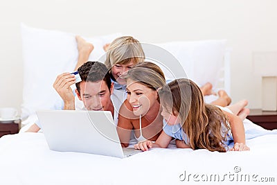 Animated family buying online lying down on bed Stock Photo