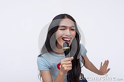 An animated and upbeat trans woman belting out a high tune, singing to lively pop song while holding a microphone. Karaoke time Stock Photo