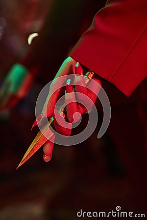 Anime woman in a red suit with short hair cut, black hair. A killer girl in a red jacket with a dagger in her hand. Beauty Stock Photo