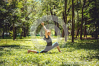 Anjaneyasana. Yoga asanas in nature. Yoga poses everyday. Practicing young woman. Yoga in the park Stock Photo