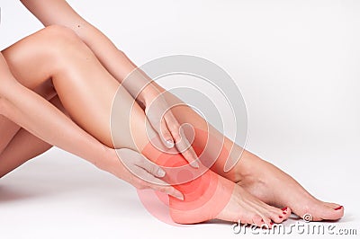 Ankle pain. Female legs. Woman massaging her ankle Stock Photo