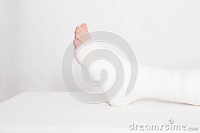 Ankle wound with a bandage in a tight fixing bandage on a white background. Concept of leg fracture and plaster bandage Stock Photo