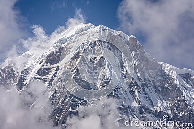 Annapurna South Summit surrounded by rising clouds in Himalayas Stock Photo