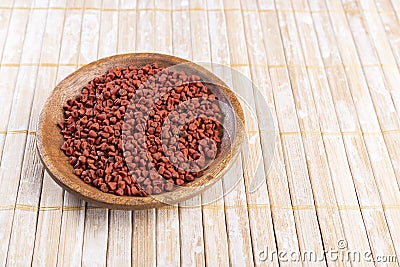 Annatto seeds on rustic wood Stock Photo