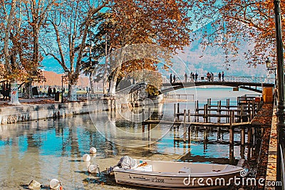 ANNECY, FRANCE - NOVEMBER 18, 2018: beautiful view at autumn Annecy lake and channel with boat, bridge and mountain at background. Editorial Stock Photo