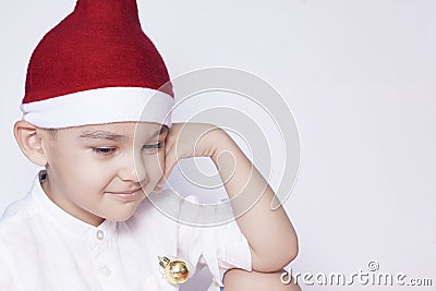 A little kid making a funny annoyed face. Annoyed Christmas Boy in Santa Hat. A really serious and handsome kid Stock Photo