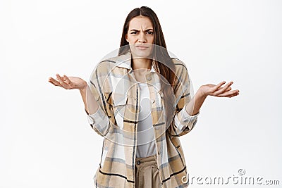 Annoyed and confused woman cant understand wtf happening, shrugging shoulders and grimacing at something ridiculous and Stock Photo