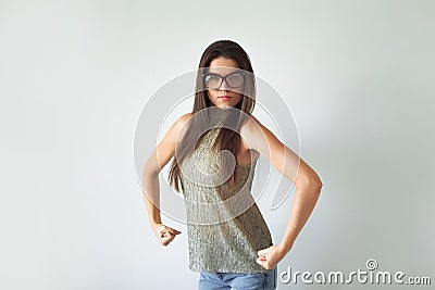 Annoyed indignant housewife, raises her hands into fists, shows strength, comic, joke. wears round transparent glasses Stock Photo