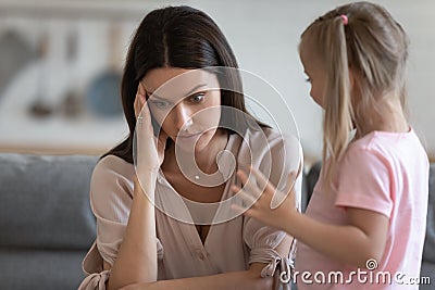 Annoyed mom and restless little daughter at home Stock Photo