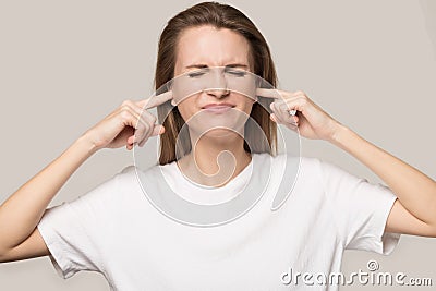 Annoyed unhappy woman plug ears with fingers, avoid loud noise Stock Photo