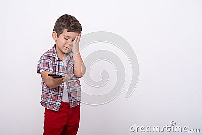 Annoyed upset little kid with smartphone reading fake news. Stock Photo