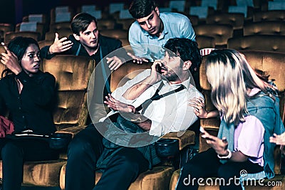 Annoying man talking on phone at movie theater Stock Photo