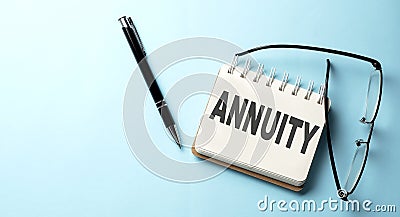 ANNUITY text is written on a notepad on the blue background Stock Photo