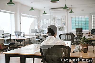 Anonymous business person working on a laptop at office desk Stock Photo