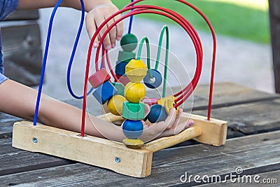 Anonymous child playing with wooden puzzle game Stock Photo