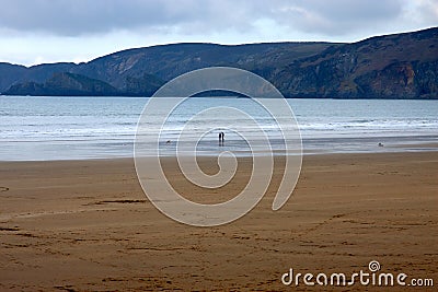 Anonymous couple in silouhette walking the beach Stock Photo