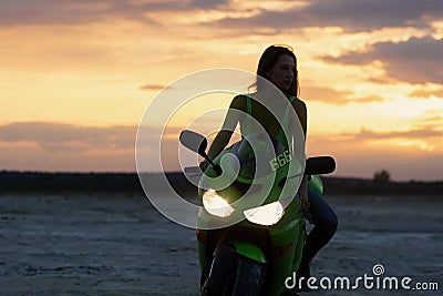 Cool woman in helmet on motorbike on beach Stock Photo