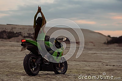 Cool woman in helmet on motorbike on beach Stock Photo