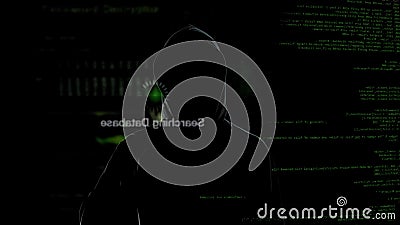 Anonymous hacker looking at virtual screen, stealing secret data, cyber crime Stock Photo