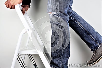 Anonymous man reaching on top of ladder climbing, indoors studio people shot Stock Photo