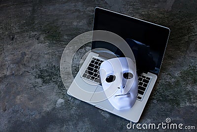 Anonymous mask to hide identity on computer laptop - internet criminal and cyber security threat concept Stock Photo