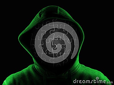 Anonymous person with face made of black jigsaw isolated on black background. Incognito mystery identikit man woman wearing hoodi Stock Photo