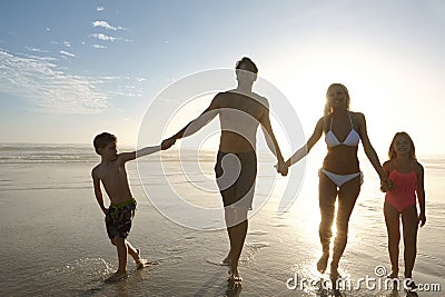 Another amazing day drawing to a close. a happy family walking on a beach at sunset. Stock Photo