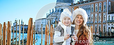 Mother and daughter travellers viewing photos on camera, Venice Stock Photo