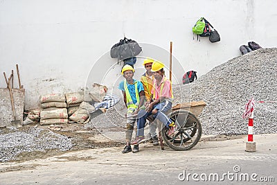 Antananarivo, Madagascar - April 24, 2019: Group of unknown Malagasy workers in hard hats and reflective jackets standing near Editorial Stock Photo