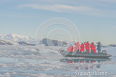 Antarctic tourists observe a leopard seal (Hydrurga leptonyx) on an ice floe in Cierva Cove from the Zodiac. Stock Photo