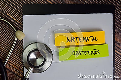Antenatal Obstetrics write on sticky notes isolated on Wooden Table Stock Photo