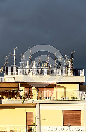 Antennas on a roof, against a cloudy sky Stock Photo