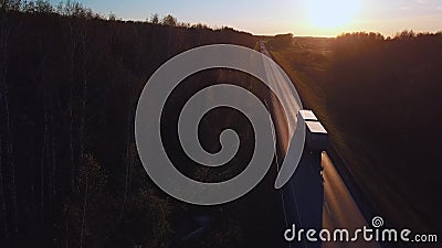 Antenne: de auto met de containerritten op de weg aan de zonsondergang De vrachtwagen berijdt de weg stock video Antenne: de auto met de containerritten op de weg aan de zonsondergang De vrachtwagen berijdt de weg stock video