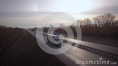 Antenne: leveringsvrachtwagens die naar de zon drijven de auto met de containerritten op de weg aan de zonsondergang Vrachtwagenr stock videobeelden Antenne: leveringsvrachtwagens die naar de zon drijven de auto met de containerritten op de weg aan de zonsondergang Vrachtwagenr stock videobeelden