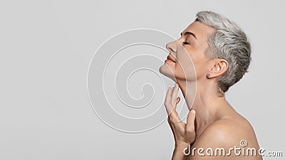 Anti-Age Treatment. Beautiful middle-aged woman touching soft skin on her neck Stock Photo