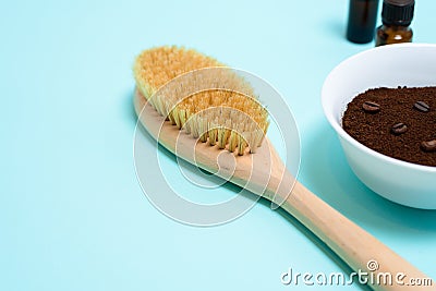 Anti-cellulite dry body massage brush, aromatherapy oil, massager and coffee scrub on blue background. Lymphatic drainage body Stock Photo