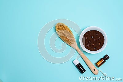 Anti-cellulite dry body massage brush, aromatherapy oil, massager and coffee scrub on blue background. Lymphatic drainage body Stock Photo