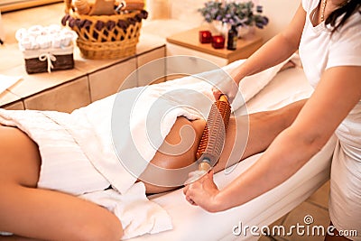 Anti-cellulite treatment with a help of a wooden roller Stock Photo