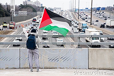 Anti-Israel Protestors Waves Palestinian Flag to Drivers on Highway 401 in Toronto Editorial Stock Photo