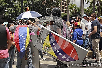 Anti Nicolas Maduro protesters wearing tear-gas mask during mass demonstrations that turned into riots in Caracas, Venezuela. Editorial Stock Photo