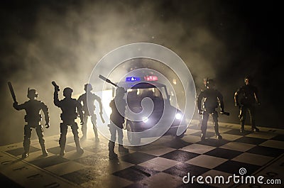 Anti-riot police give signal to be ready. Government power concept. Police on chessboard. Smoke on a dark background with lights. Stock Photo