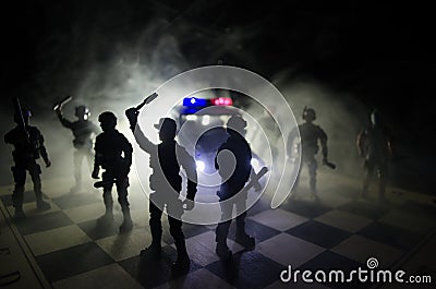 Anti-riot police give signal to be ready. Government power concept. Police on chessboard. Smoke on a dark background with lights. Stock Photo