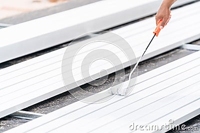 Anti-rust paint, Paint roller on the rustproof steel during painting in construction site Stock Photo