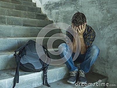 Campaign vs homophobia with young sad and depressed college student man sitting on staircase desperate victim of harassment Stock Photo