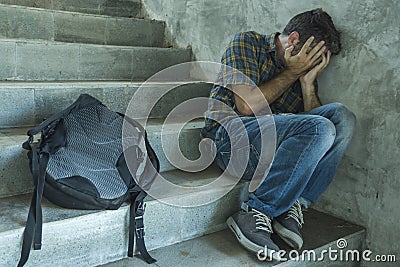 Campaign vs homophobia with young sad and depressed college student man sitting on staircase desperate victim of harassment Stock Photo