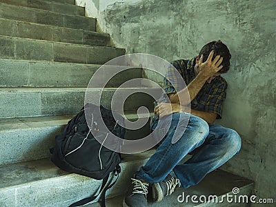 Campaign vs homophobia with young sad and depressed college student man sitting on staircase desperate victim of harassment Stock Photo